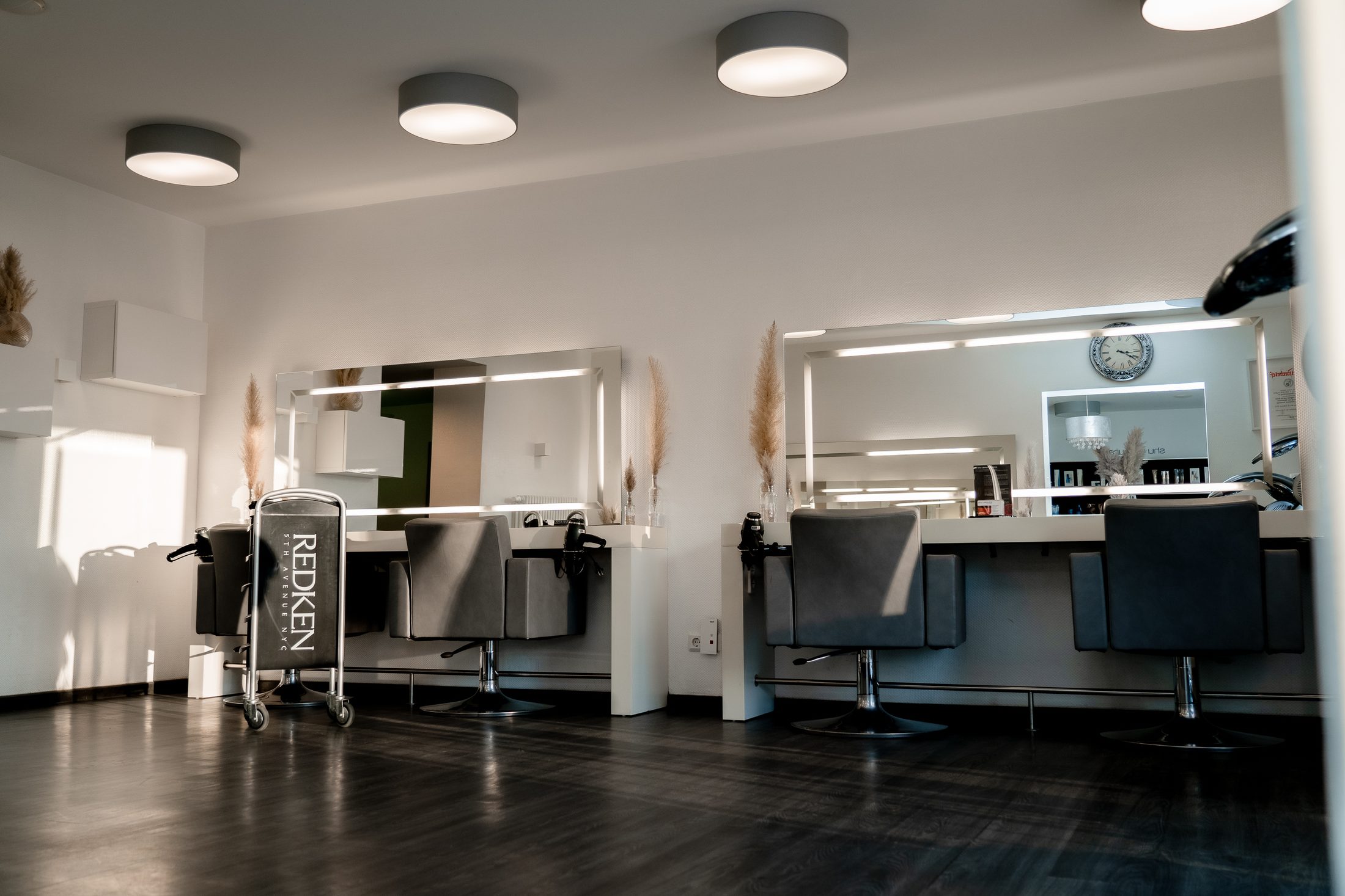 Stilvolle Arbeitsplätze mit beleuchteten Spiegeln im Friseursalon Ayhan Haare & Gesicht, Blieskastel Saarland